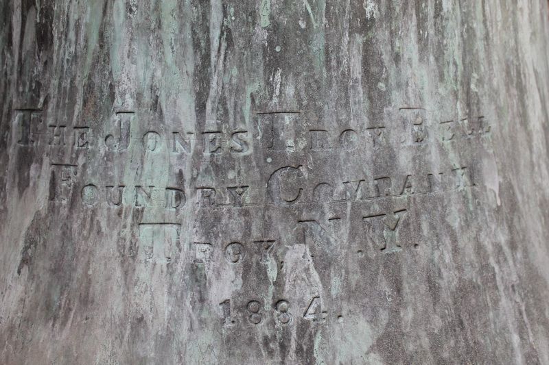 The bell's bronze surface with the raised inscription 'The Jones Troy Bell Foundry Company, Troy, N.Y. 1884'.