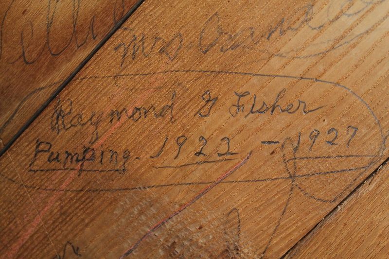 A pencilled inscription on the bellows door reading 'Raymond G. Fisher, Pumping 1922-1927'.